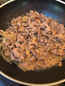Cooking gyudon beef, liquid is cooked down into slightly thicker sauce