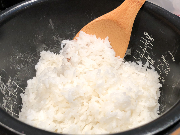 Fluffing Japanese rice with a wooden spoon