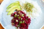 A plate of spicy beet poke with avocado and rice with furikake
